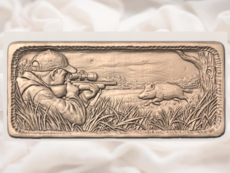 Puede incluir: Un relieve rectangular marr&oacute;n representa a un cazador apuntando con un rifle a un jabal&iacute; en un campo cubierto de hierba. La obra de arte detallada incluye un &aacute;rbol, follaje y un borde en forma de cuerda.