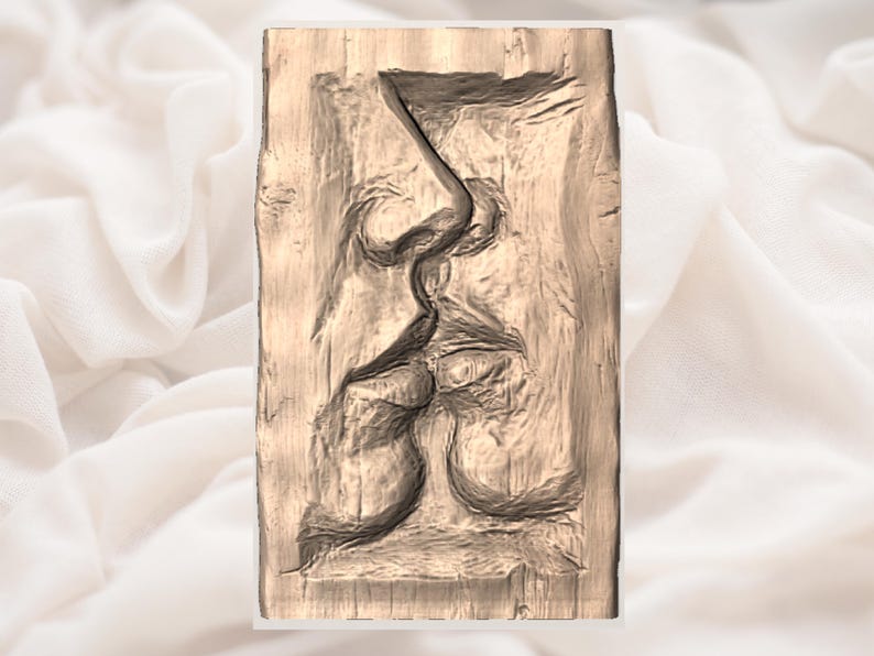 May include: A rectangular wooden carving depicting a side profile of a face, with the nose, lips, and chin prominently featured. The carving has a textured surface and is in shades of brown.
