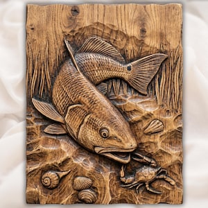 May include: A detailed wood carving of two fish, a crab, and seashells. The fish are carved in a realistic style, with scales and fins visible. The carving is set against a background of carved water and reeds. The wood has a warm, natural tone.