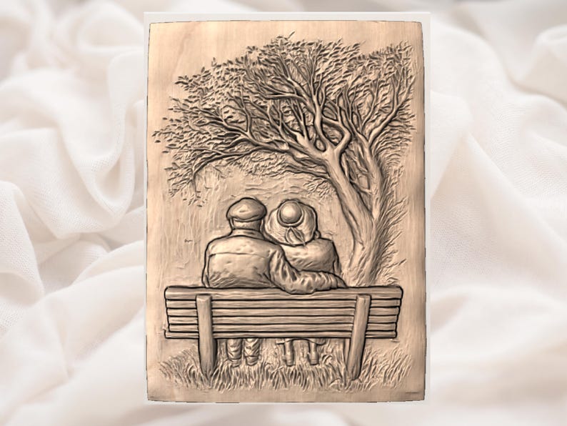 May include: A wooden relief carving depicts an elderly couple seated on a park bench beneath a tree. The artwork is detailed, showing the figures' clothing and the tree's foliage. The piece has a warm, natural wood tone and is framed.