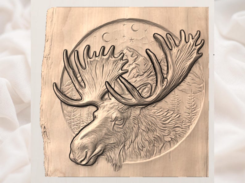 Peut inclure: Une sculpture en bois d&eacute;taill&eacute;e d'une t&ecirc;te d'orignal avec de grands bois. L'orignal est plac&eacute; sur un fond circulaire repr&eacute;sentant une cha&icirc;ne de montagnes, des arbres, des &eacute;toiles et des croissants de lune. La sculpture est dans des tons bruns et beiges.