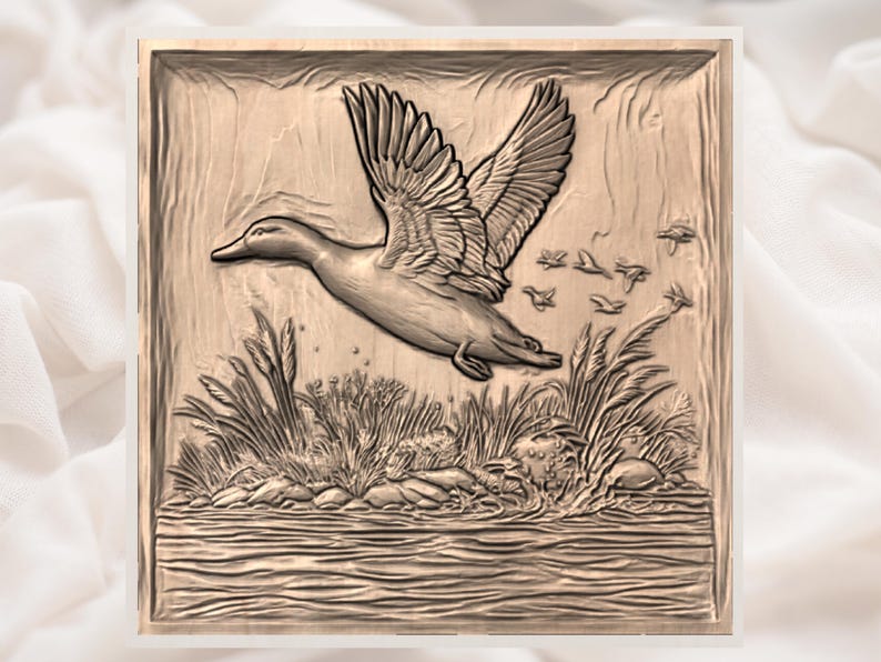 May include: A detailed relief carving of a duck in flight, wings spread, above reeds and water. The artwork is in a square frame with a natural, earthy tone, and a flock of smaller birds follows the duck.