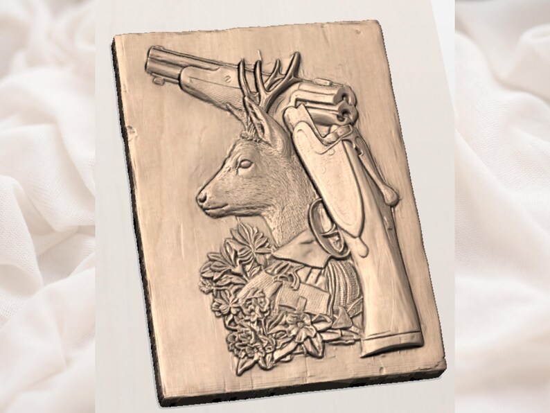 Pu&ograve; includere: Un'incisione a rilievo color bronzo su una placca di legno rettangolare. Il disegno presenta una testa di cervo con corna, un fucile e una composizione floreale. L'intaglio &egrave; dettagliato e ha un'estetica rustica.