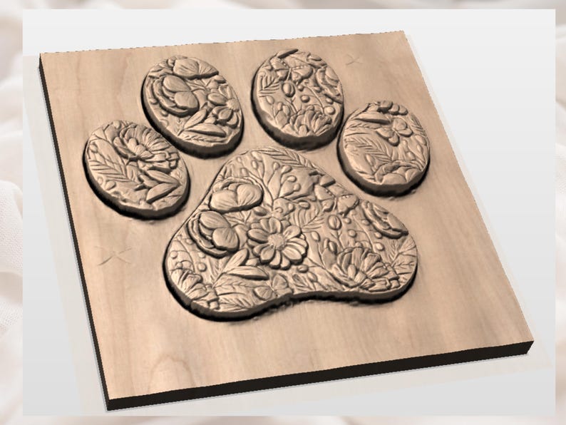 Puede incluir: Una talla de madera con forma de huella de pata con dise&ntilde;os florales y bot&aacute;nicos. La huella de la pata est&aacute; tallada en una superficie de madera de color marr&oacute;n claro. Las almohadillas y los dedos est&aacute;n decorados con patrones florales detallados.