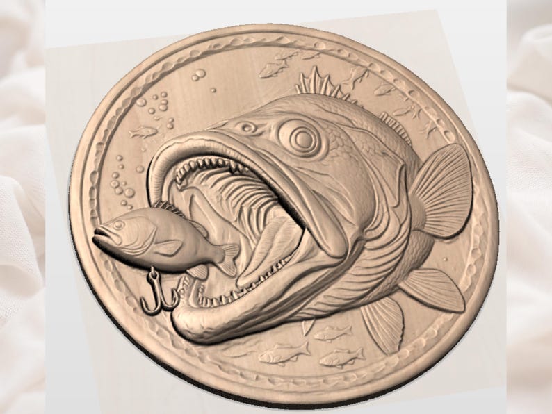 Puede incluir: Un detallado relieve de color bronce de un pez grande con la boca abierta, consumiendo un pez m&aacute;s peque&ntilde;o. Se ve un anzuelo. El dise&ntilde;o es circular, con peces y burbujas adicionales en los bordes, sugiriendo un tema de pesca o n&aacute;utico.