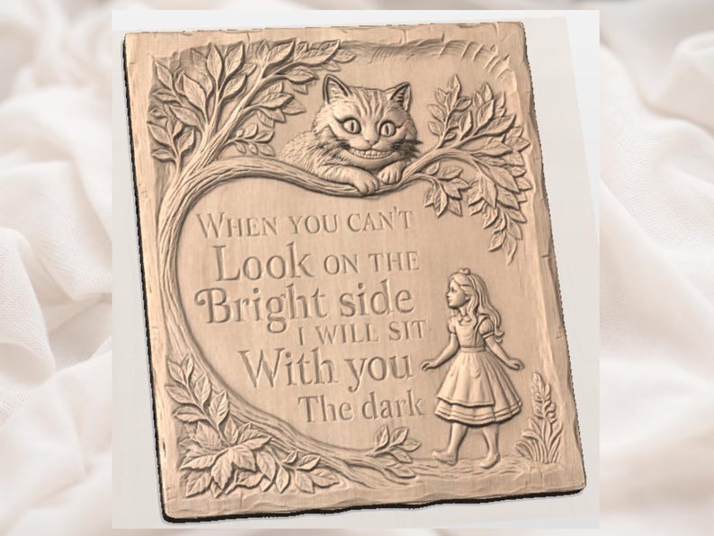 May include: A rectangular, beige-colored plaque with a carved design featuring a Cheshire Cat, Alice, and text from Alice in Wonderland. The text reads "When you can't look on the bright side, I will sit with you in the dark."