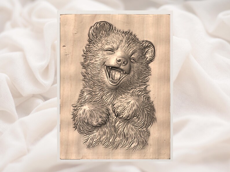 May include: A wooden relief carving of a laughing bear cub. The bear is depicted with its mouth wide open, showing its teeth, and its paws are raised. The carving is detailed, with visible fur texture and facial features. The background is a light-colored wood.