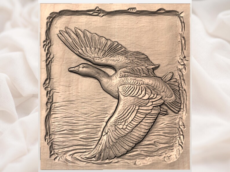 May include: A detailed wood carving of a goose in flight, wings outstretched, above water. The artwork is framed with a decorative border. The carving is in shades of brown and beige, creating a natural and rustic aesthetic.