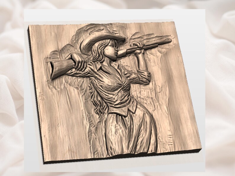 May include: A detailed wood carving of a woman in a cowboy hat holding a rifle. The relief sculpture is in shades of brown and beige, depicting a figure in a shirt and skirt, aiming the rifle. The carving is mounted on a wooden plaque.