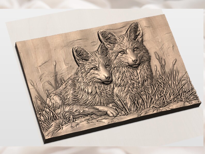 Op de afbeelding: Een gedetailleerde houtsnijwerk van twee vossen die in een grasveld bij elkaar zitten. Het kunstwerk is uitgevoerd in bruintinten en heeft ingewikkelde texturen, die de vacht en de natuurlijke omgeving laten zien. Het stuk is op een donker frame gemonteerd.
