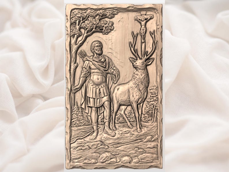 May include: A detailed relief carving depicts a man with a halo, bow and arrow, and a deer with a crucifix between its antlers. The artwork is in a rectangular frame with a natural wood-like appearance, showcasing a forest scene.