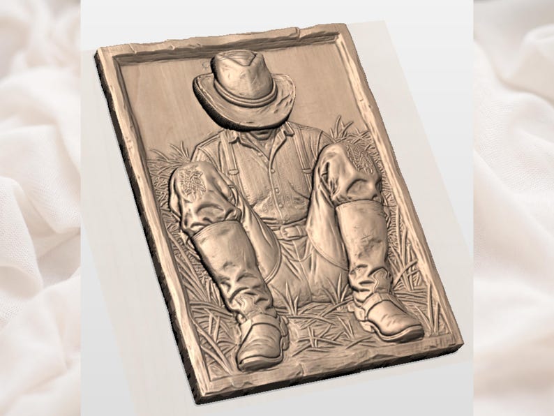 May include: A bronze-toned relief sculpture showing a seated figure wearing a cowboy hat, shirt, braces, and boots. The figure is set amongst grass, within a rectangular frame. The artwork has a rustic, vintage appearance, with detailed textures.