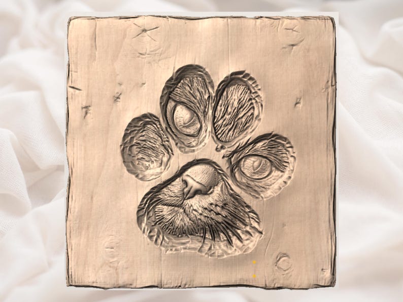 May include: A square wooden plaque featuring a carved paw print. The paw print is detailed with textured pads and claw marks. The wood is light brown with visible grain and some imperfections.