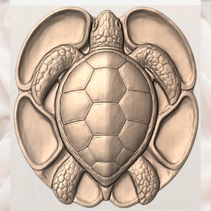 May include: A circular light brown wooden serving tray featuring a carved sea turtle in the center. The turtle is depicted with a detailed shell and textured flippers, surrounded by six smooth, recessed compartments integrated into the tray design.