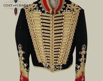 May include: Black military-style jacket with gold embellishments and buttons. The jacket features a red collar and cuffs, and intricate gold embroidery on the sleeves and front. The jacket is hanging on a white hanger.