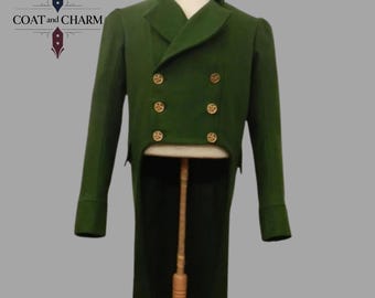 Könnte beinhalten: Ein grüner Gehrock mit goldenen Knöpfen und schwarzem Kragen, präsentiert auf einer Schaufensterpuppe. Der Mantel hat lange Ärmel und ein zweireihiges Design. Der Text "COAT and CHARM" ist sichtbar. Ein klassisches Kleidungsstück.