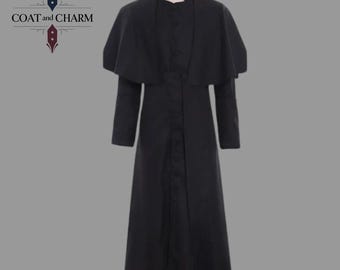 May include: A black, full-length coat with a high collar and a cape-like overlay. The coat has long sleeves and a button-down front. The text "COAT and CHARM" is visible in the upper left corner. The coat is displayed on a mannequin.
