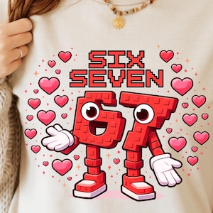 May include: Beige t-shirt featuring a graphic of the numbers "SIX" and "SEVEN" as cartoon characters, surrounded by pink hearts. The numbers are red with white gloves and shoes. The text "SIX SEVEN" is above the characters.