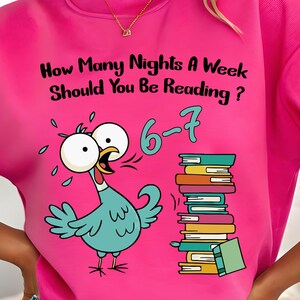 May include: Hot pink sweatshirt with the text "How Many Nights A Week Should You Be Reading?" and a cartoon turkey with a stack of books. The text "6-7" is also displayed. The sweatshirt is paired with blue denim shorts.