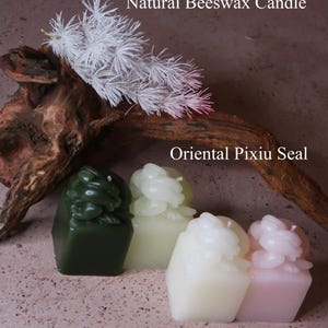 May include: Four colorful Oriental Pixiu seals and a natural beeswax candle are displayed. The seals are green, light green, white, and pink. The candle is white. The text "Natural Beeswax Candle" and "Oriental Pixiu Seal" are visible.