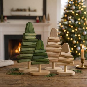 May include: A set of four decorative wooden trees standing on oval bases. Two trees are finished in varying shades of green, while the other two feature a natural light wood finish. Each tree is constructed from stacked horizontal wooden segments.