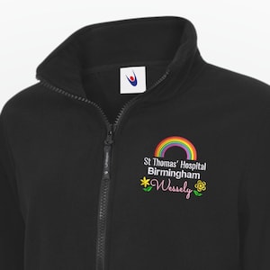 May include: Black fleece jacket with a full zipper and a high collar. The jacket features a rainbow and floral design with the text "St Thomas' Hospital Birmingham" and "Wessly".