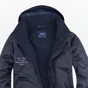 May include: Navy blue hooded jacket with a full zipper closure. The jacket has a high collar and a soft inner lining. The text "Your Text or Logo Embroidered Here" is visible on the left chest area. The jacket is designed for outdoor wear.