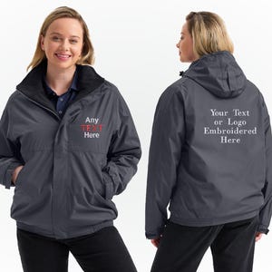 May include: A dark grey jacket with a black collar and hood. The front of the jacket has the text "Any TEXT Here" embroidered in red and white. The back of the jacket has the text "Your Text or Logo Embroidered Here" in white.