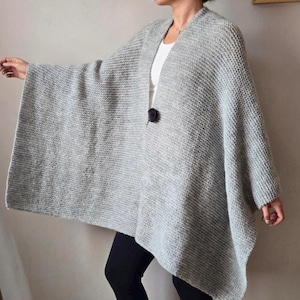 Grijze gebreide poncho van wolmix, minimalistische sjaal met knoopsluiting aan de voorkant