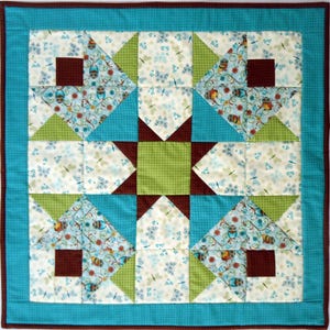 May include: A square quilt featuring a central lime green square surrounded by dark brown star points. The design includes blocks with light blue butterfly and owl patterns, lime green triangles, and a bright turquoise border with a dark brown edge.