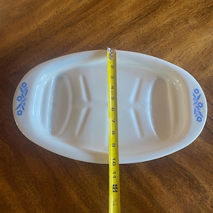 May include: A white ceramic mug with a black handle and the text "But First, Coffee" in a handwritten style. The mug is on a white surface. The mug is approximately 4 inches tall.