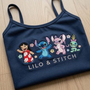 May include: Navy blue vest top featuring embroidered characters from Lilo & Stitch. The design includes Lilo in a red dress, Stitch, Angel, and a green doll, with the text "LILO & STITCH" below.
