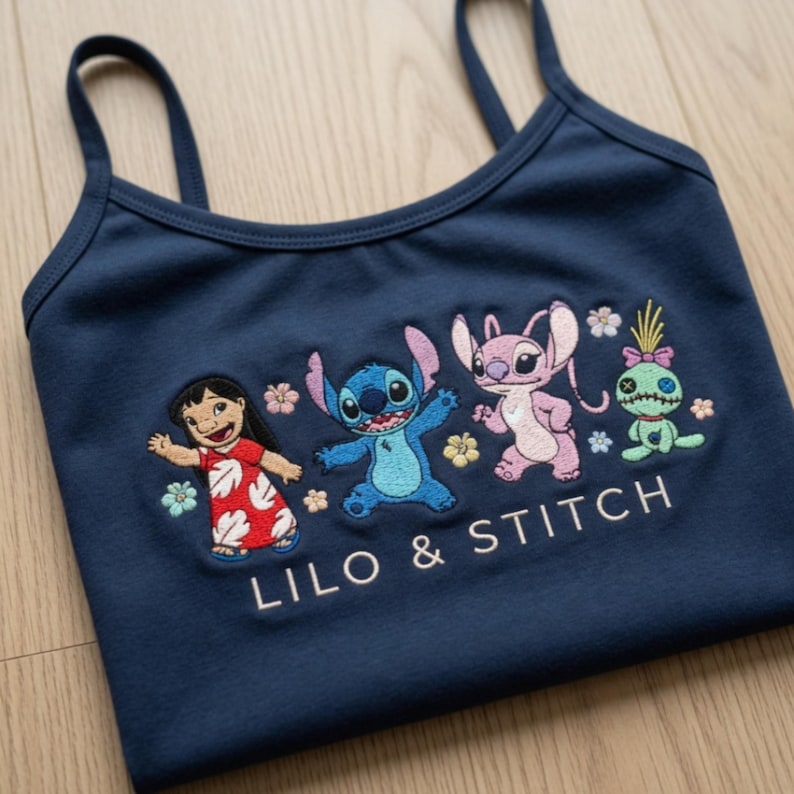 May include: Navy blue vest top featuring embroidered characters from Lilo & Stitch. The design includes Lilo in a red dress, Stitch, Angel, and a green doll, with the text "LILO & STITCH" below.