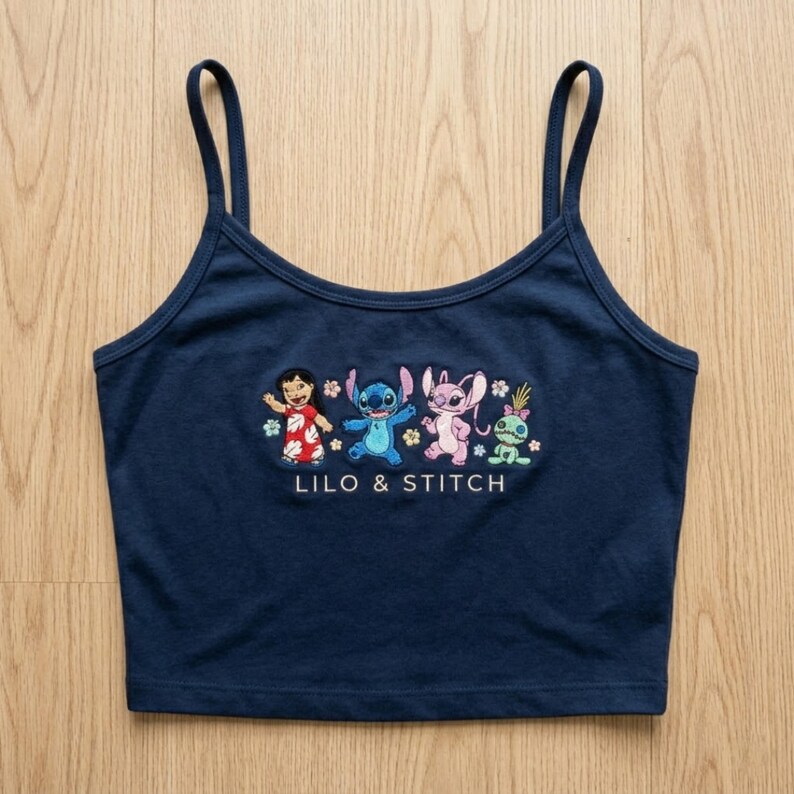 May include: Navy blue camisole top with an embroidered design of Lilo & Stitch characters. The design includes Lilo, Stitch, Angel, and a green alien. The words "LILO & STITCH" are embroidered below the characters.
