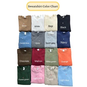 May include: A color chart displaying a variety of sweatshirts in different colors. The chart includes colors such as brown, white, beige, black, blue, gray, green, orange, pink, and sand. The text "Sweatshirt Color Chart" is at the top.