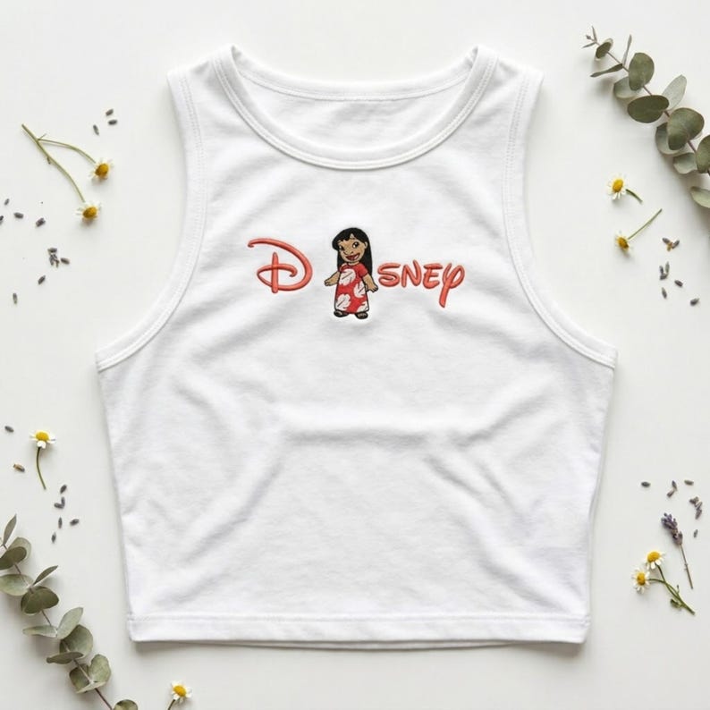 May include: White tank top with a red and pink Disney logo featuring a cartoon character. The sleeveless top is made of a soft material and is suitable for casual wear.