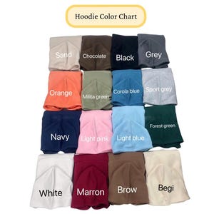 May include: A color chart for hoodies, featuring a variety of colors including sand, chocolate, black, grey, orange, military green, corolla blue, sport grey, navy, light pink, light blue, white, maroon, brown, and beige. The text "Hoodie Color Chart" is at the top.