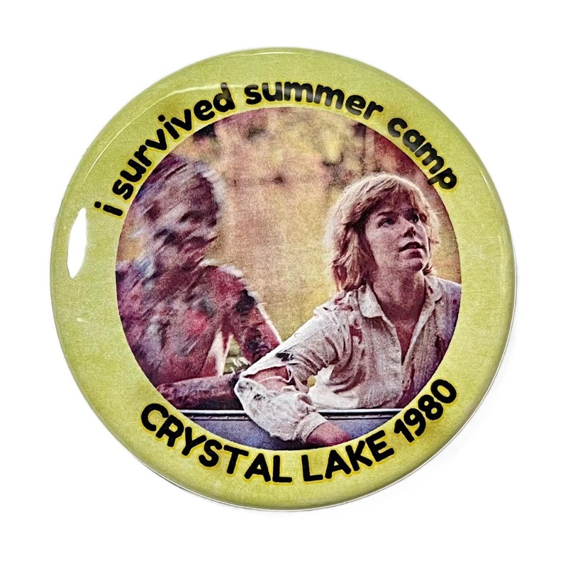Puede incluir: Un bot&oacute;n amarillo con una imagen de una persona joven mirando hacia arriba y una figura borrosa detr&aacute;s de ella. El bot&oacute;n dice "Sobreviv&iacute; al campamento de verano Crystal Lake 1980".