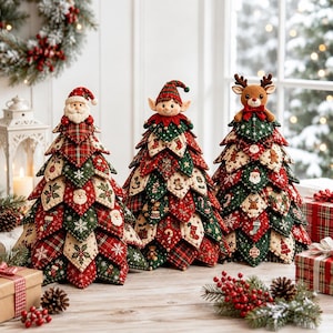 May include: Three decorative fabric Christmas trees featuring quilted, layered leaf patterns in red, green, and cream. The trees are topped with plush figures of Santa Claus, an elf, and a reindeer, each adorned with festive holiday-themed fabric prints.