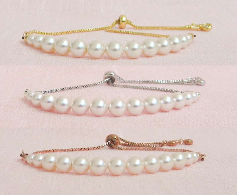 May include: Three pearl bracelets with adjustable sliding knots. The bracelets are shown on a pink background. The first bracelet has a gold chain, the second has a silver chain, and the third has a rose gold chain.