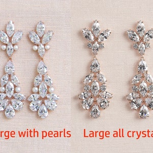 May include: Two pairs of dangle earrings with a rose gold setting. The earrings on the left have clear crystals and pearls. The earrings on the right have all clear crystals. The text "Large with pearls" is below the left earrings and "Large all crystal" is below the right earrings.