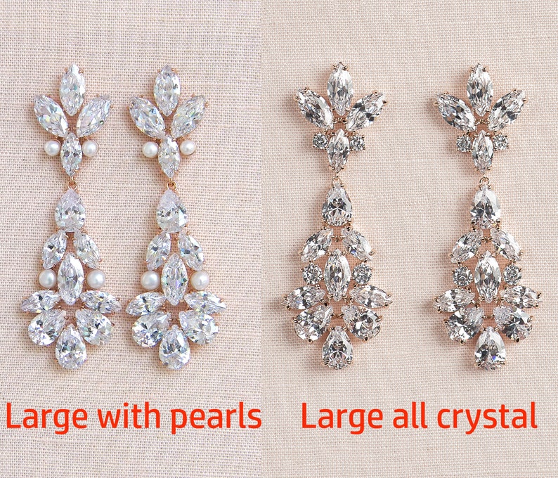 May include: Two pairs of dangle earrings with a rose gold setting. The earrings on the left have clear crystals and pearls. The earrings on the right have all clear crystals. The text "Large with pearls" is below the left earrings and "Large all crystal" is below the right earrings.
