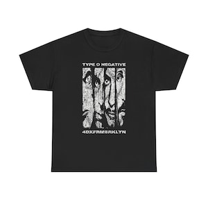 May include: Black t-shirt featuring a white graphic of stylized faces and the text "TYPE O NEGATIVE" above and "4DXFRMBRKLN" below. The design is distressed, giving it a vintage look. The shirt is made of a soft material.