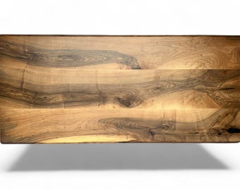 May include: A rectangular wooden table top with a natural wood grain pattern. The wood has a mix of light and dark brown tones, with visible knots and swirls. The table top is approximately 60 inches long and 30 inches wide.