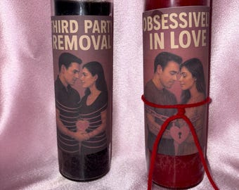 May include: Two glass jar candles. One is black with the text "THIRD PARTY REMOVAL" and an image of a couple. The other is red with the text "OBSESSIVELY IN LOVE" and a similar image. A red string is tied around the second candle.