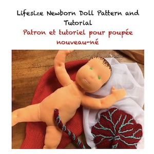 May include: A handmade, life-size newborn doll with a peach-colored body, brown hair, and green eyes. The doll is lying on a red knitted hat and white fabric. The image includes text that reads "Lifesize Newborn Doll Pattern and Tutorial".