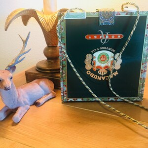 Monedero THIN Cigar Box de color verde oscuro con correa para el hombro de cordón dorado y forro de tela personalizada con estampado floral verde oliva