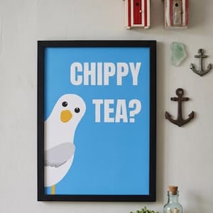 Könnte beinhalten: Gerahmter Druck mit blauem Hintergrund und den weißen Worten "CHIPPY TEA?". Eine Cartoon-Möwe schaut von links. Dekorative Elemente sind Miniatur-Strandhütten, Anker und ein Regal mit Pflanze und Flasche.