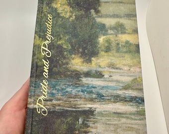 May include: A copy of "Pride and Prejudice" by Jane Austen. The book's cover displays a landscape painting in shades of green, blue, and beige. The title and author's name are written in gold.