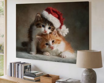 May include: A canvas print featuring two kittens. One kitten is wearing a red and white Santa hat. The other kitten is orange and white. The artwork is displayed on a white wall above a wooden cabinet.